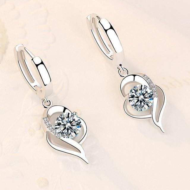The 925 Sterling Silver and Zirconia Inlaid Floral Earrings showcase a handcrafted floral design with sparkling zirconia accents, emphasizing elegance and beauty on a soft, light background.